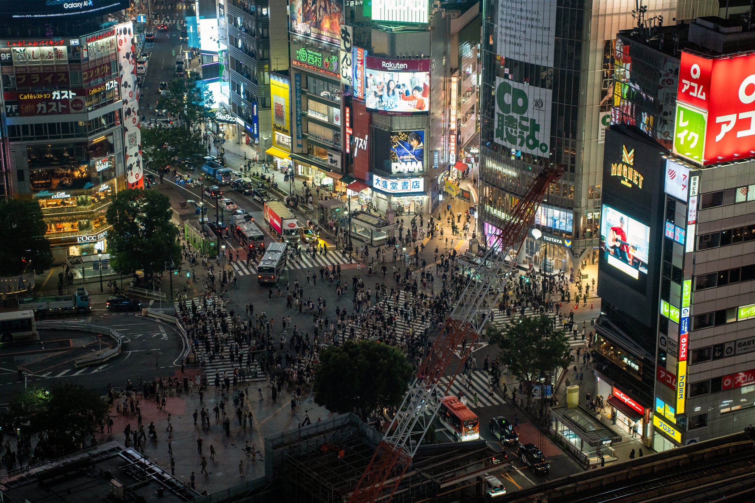 Aerial night view of Shibuya Crossing with neon lights and crowds of people